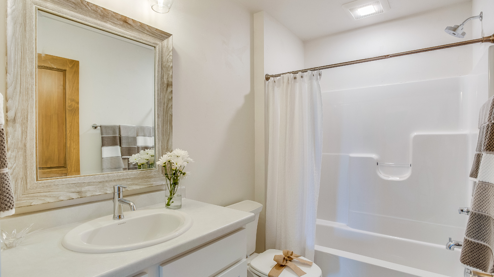 A bathroom with a sink, mirror, and bathtub